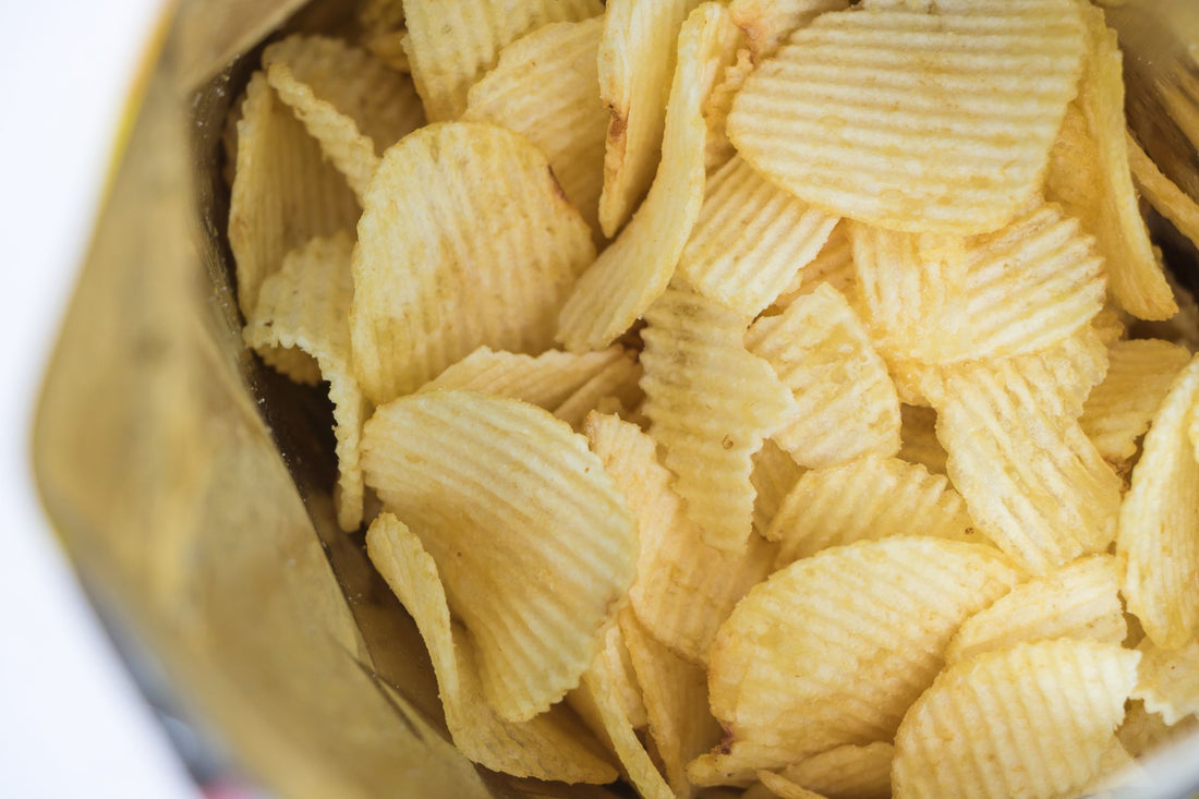 Close-up of ridged potato chips in an open bag, showcasing texture and crunch.