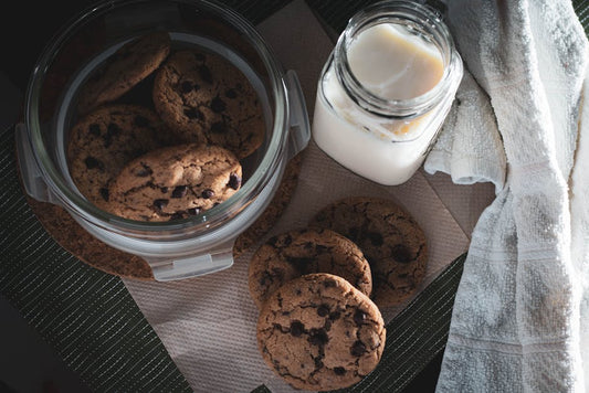 A tempting overhead view of chocolate chip cookies and a glass of milk.