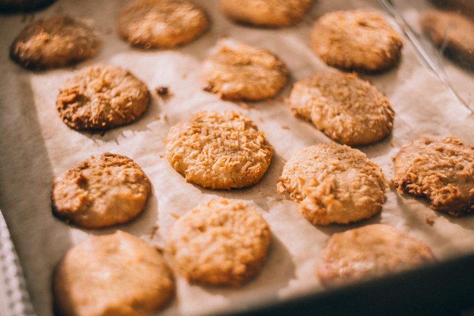 Close-up of freshly baked cookies on a parchment-lined tray, showcasing a golden, crispy texture.