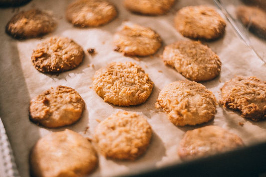 Close-up of freshly baked cookies on a parchment-lined tray, showcasing a golden, crispy texture.