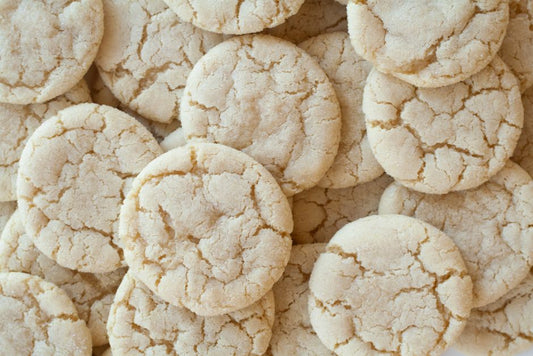 A close-up shot of homemade sugar cookies with a cracked surface, showcasing their texture.