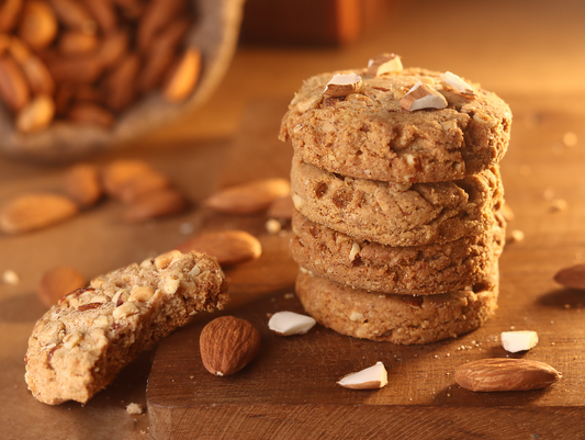 Delicious stack of almond chocolate chip cookies on a rustic wooden surface.