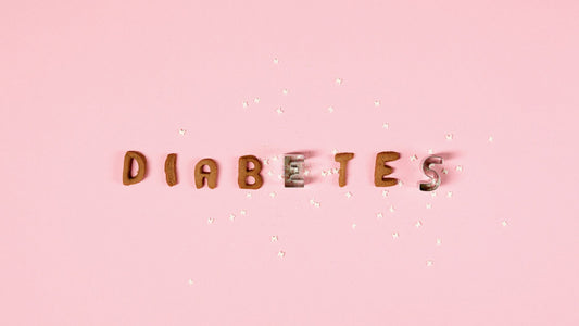 Pink background with the word 'Diabetes' formed from cookie cutters and sugar pieces.