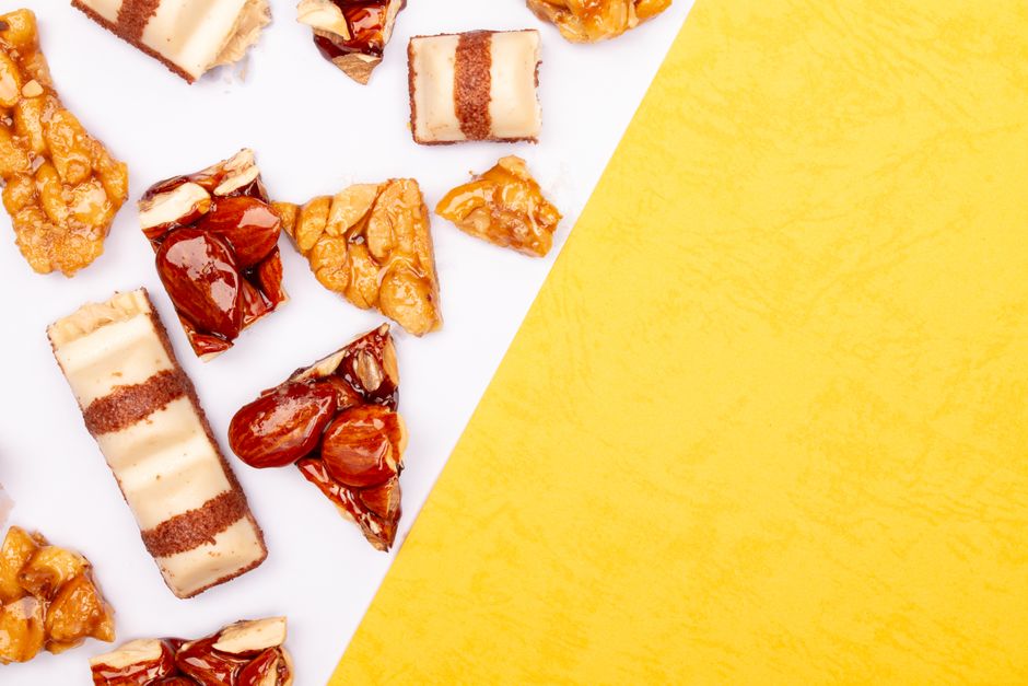 A flat lay of assorted nutty pastries on a vibrant yellow and white background.