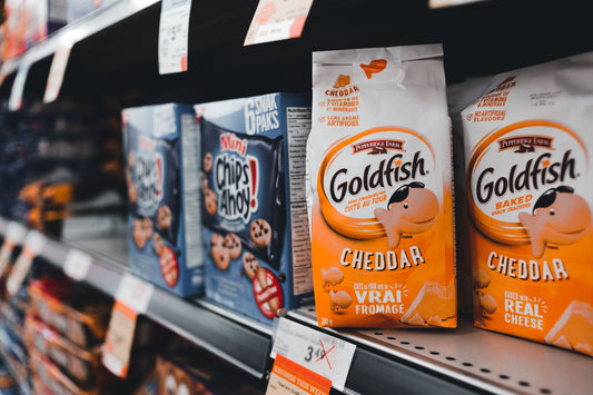A tilt shot of Goldfish and Chips Ahoy snacks on a retail store shelf.